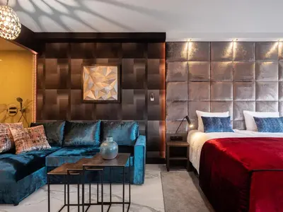 a hotel room with a bed and a couch at Art Suites Boutique Hotel - Krakow Center in Kraków