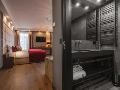 a bathroom with a sink and a bed in a room at Art Suites Boutique Hotel - Krakow Center in Kraków