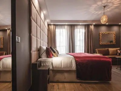 a bedroom with a large bed with a red blanket at Art Suites Boutique Hotel - Krakow Center in Kraków