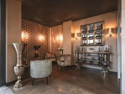 a room with chairs and a table and a shelf at Art Suites Boutique Hotel - Krakow Center in Kraków