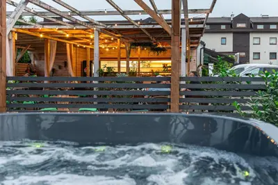 a hot tub in a backyard with a building at Old Tree Villa & Restaurant in Oświęcim