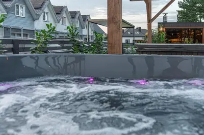 a hot tub with pink lighting in a backyard at Old Tree Villa & Restaurant in Oświęcim