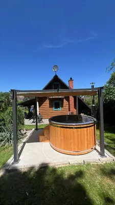 a large wooden tub in front of a house at Domek pod Jaworami z balią in Sułkowice