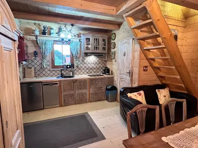 a kitchen with a spiral staircase in a log cabin at Domek pod Jaworami z balią in Sułkowice