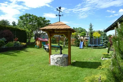 a wooden gazebo in a yard with a cross at Domek pod Jaworami z balią in Sułkowice