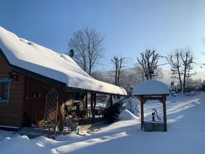a building covered in snow with a gazebo at Domek pod Jaworami z balią in Sułkowice