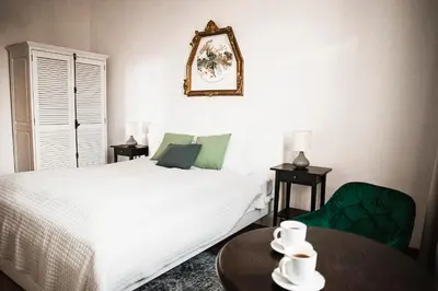 a bedroom with a bed and a table and a mirror at Vilao Apartments in Kraków