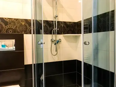 a shower with a glass door in a bathroom at OSADA WASYLÓWKA in Laskowa