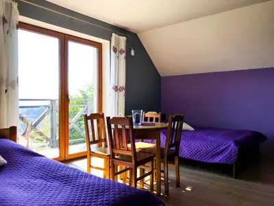 a bedroom with two beds and a table with chairs at OSADA WASYLÓWKA in Laskowa