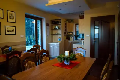 a kitchen and dining room with a wooden table with a candle at OSADA WASYLÓWKA in Laskowa