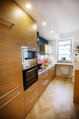 a kitchen with wooden cabinets and a microwave at Bochenka Apartments in Kraków