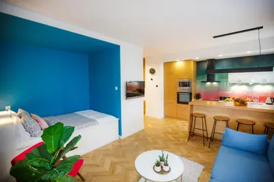 a small room with a bed and a kitchen at Bochenka Apartments in Kraków