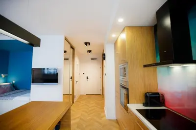 a room with a kitchen and a living room at Bochenka Apartments in Kraków