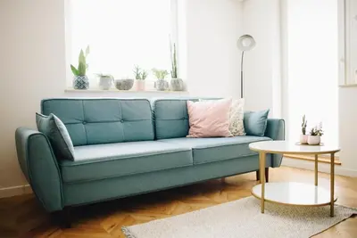a blue couch in a living room with a table at Bochenka Apartments in Kraków