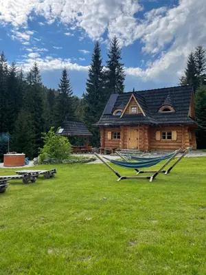 a log cabin with hammocks in front of it at Domek na Cepcowym in Obidowa