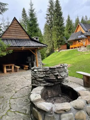 a stone fire pit in a yard next to a building at Domek na Cepcowym in Obidowa