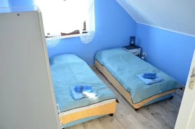 two beds in a room with blue walls at Pokoje gościnne u Grażki in Jerzmanowice