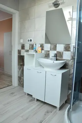 a white bathroom with a sink and a mirror at Pokoje gościnne u Grażki in Jerzmanowice