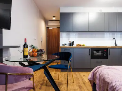 a kitchen with a table with a bottle of wine at Aparthotel Inspire Miodova Residence in Kraków