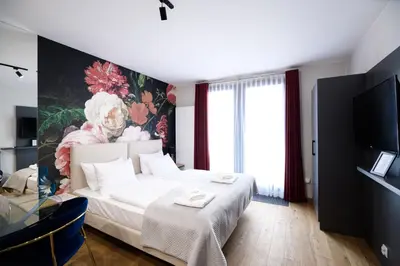 a bedroom with a bed and a painting on the wall at Aparthotel Inspire Miodova Residence in Kraków