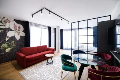 a living room with a red couch and a glass table at Aparthotel Inspire Miodova Residence in Kraków