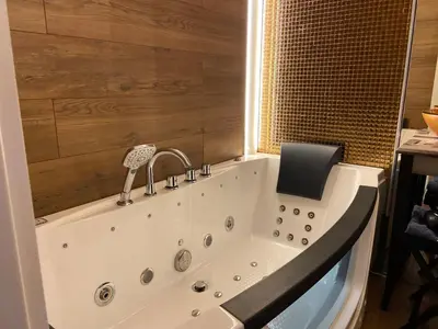 a bathroom with a bath tub with a box on it at Rakowicka Top Apartaments Superior in Kraków