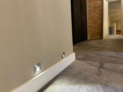a hallway with a white wall with lights on it at Rakowicka Top Apartaments Superior in Kraków
