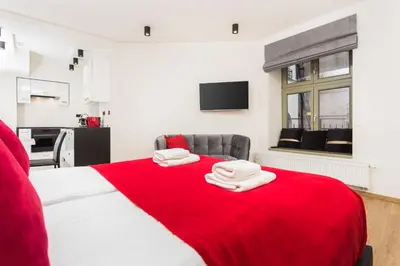 a bedroom with a large bed with a red blanket at InPoint Krupnicza Apartment - 5 minut from Main Square Self Check-in in Kraków