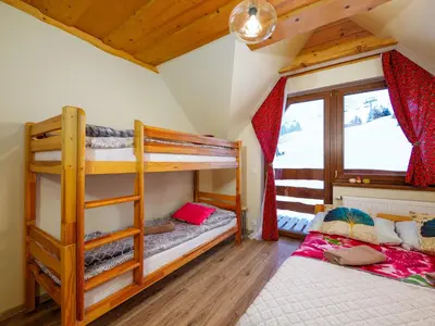 a bedroom with two bunk beds and a window at Gazdówka na Mosornym Groniu in Zawoja