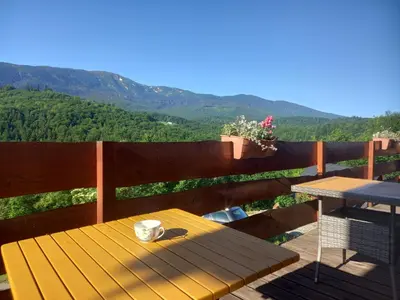 a chair on a deck with a view of the mountains at Gazdówka na Mosornym Groniu in Zawoja