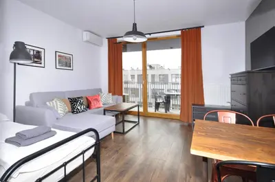a living room with a couch and a table at Schindler’s Factory Zabłocie Deluxe Apartments WAWELOFTS in Kraków