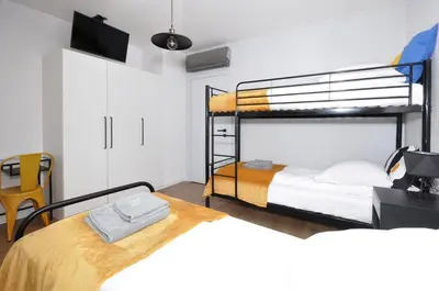 a bedroom with two bunk beds and a tv at Schindler’s Factory Zabłocie Deluxe Apartments WAWELOFTS in Kraków
