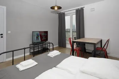a bedroom with a bed and a table with a television at Schindler’s Factory Zabłocie Deluxe Apartments WAWELOFTS in Kraków