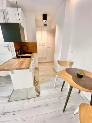 a kitchen with white cabinets and a table and a tableablish at SKALNY apartamenty, pokoje in Ogrodzieniec