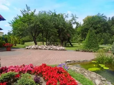 a garden with flowers and a horse in the background at SKALNY apartamenty, pokoje in Ogrodzieniec