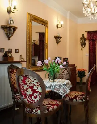 a room with a table with chairs and a mirror at Red Carpet Premium in Kraków