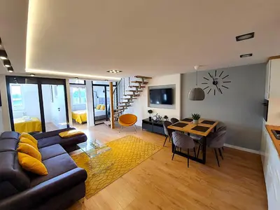 a living room with a couch and a table at Duplex apartment Morsztynowska in Kraków
