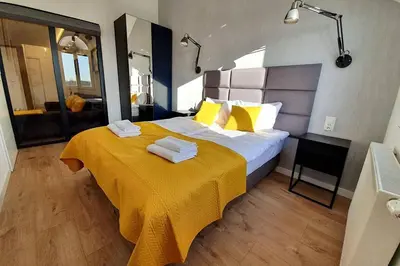 a bedroom with a large bed with a yellow blanket at Duplex apartment Morsztynowska in Kraków