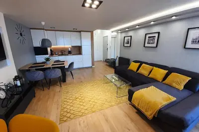 a living room with a couch and a dining room at Duplex apartment Morsztynowska in Kraków