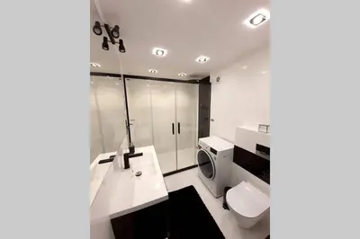 a white bathroom with a toilet and a sink at Duplex apartment Morsztynowska in Kraków