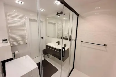 a bathroom with a glass shower and a sink at Duplex apartment Morsztynowska in Kraków