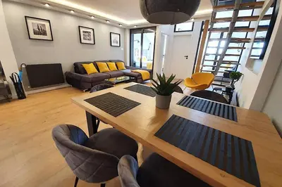 a living room with a wooden table and chairs at Duplex apartment Morsztynowska in Kraków