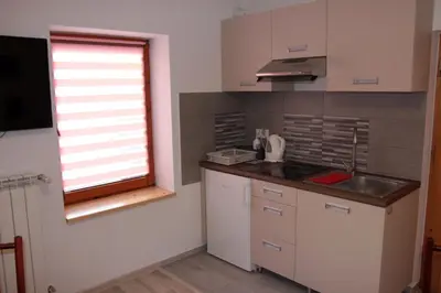 a bedroom with two beds and a table with a chair at Apartament U Jacka 2 in Rabka