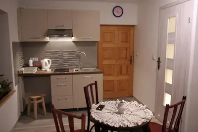 a kitchen with white cabinets and a sink at Apartament U Jacka 2 in Rabka