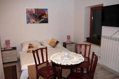 a bedroom with a bed and a table with a cat on it at Apartament U Jacka 2 in Rabka