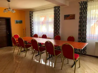 a conference room with a wooden table and red chairs at Dom u Kasi in Podwilk