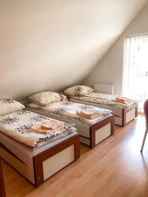 three beds in a room with a attic at Agroturystyka Kasia in Podwilk