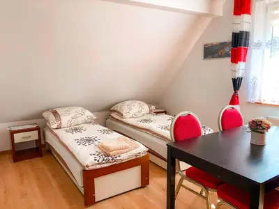 a room with two beds and a table and chairs at Agroturystyka Kasia in Podwilk