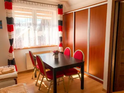 a dining room with a black table and red chairs at Agroturystyka Kasia in Podwilk