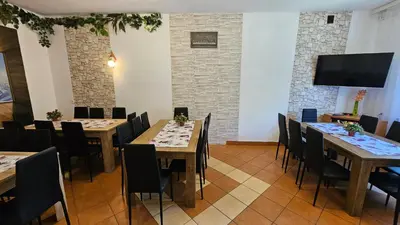 a dining room with tables and chairs and a flat screen tv at Agroturystyka na szlaku in Lubomierz
